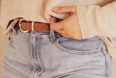 A woman is wearing a leather belt that was handcrafted in America.