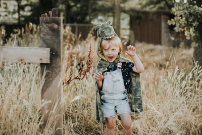 A boy runs around in a field with shorts and a tee made in America.