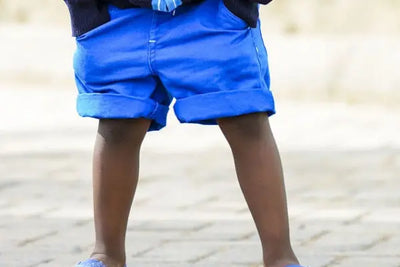 A boy wearing blue shorts.