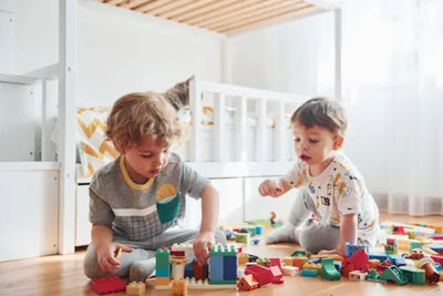 Two boys playing with toys while wearing their American made shirts.