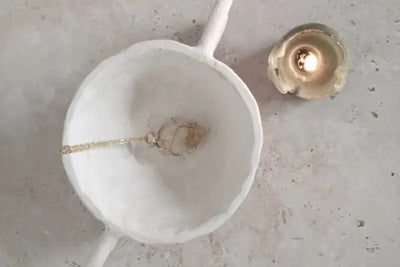 A crystal necklace sitting in a jewelry dish.