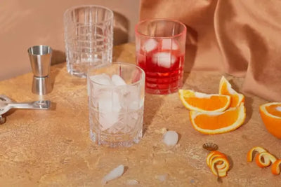 Three glasses and orange peels for drinks. 