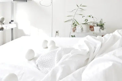 100% American made cotton balls sitting on a bed.