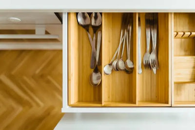 Silverware made in America sit in a wooden kitchen storage organizer. 