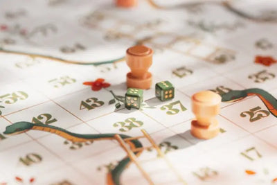 Two green dice are rolled on a colorful snakes and ladders game board with player pieces.