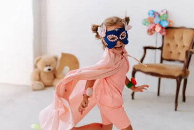 A girl wearing a pink costume and blue costume mask.
