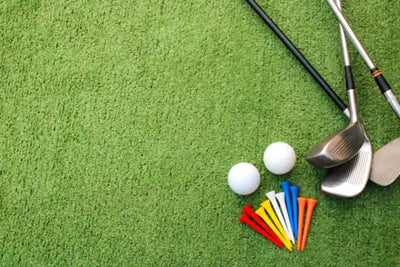Golf clubs, tees, and balls on green turf.