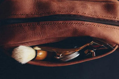 A leather dopp kit holding grooming supplies.