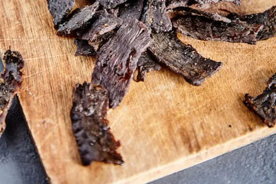 Beef jerky on a board.