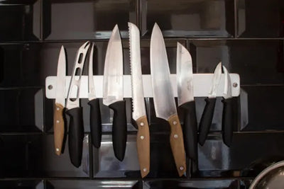 Knives neatly organized on a magnet rack.