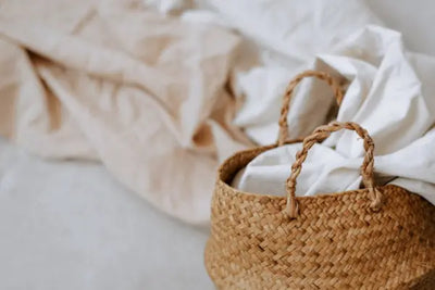 Two American made lightweight bedding blankets sitting next to a basket. 