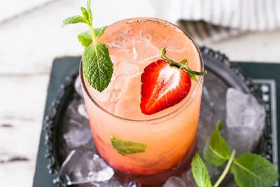 A natural strawberry mixer with mint is mixed with an alcoholic beverage. 