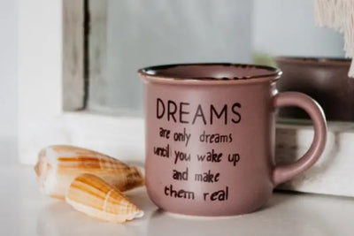 A pinkish-brown ceramic mug with the text 