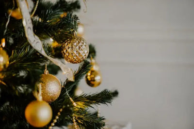Three golden ornaments on a tree.