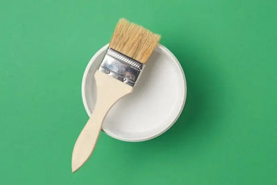 A white paint brush and can.