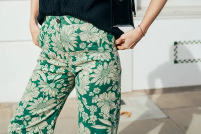 A woman wearing a green and white floral designed pair of pants that were made in America.