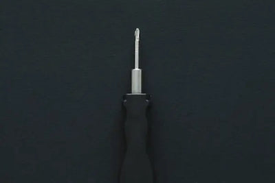 A screwdriver on a black tabletop 
