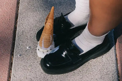 Ice cream spilt on black shoes.