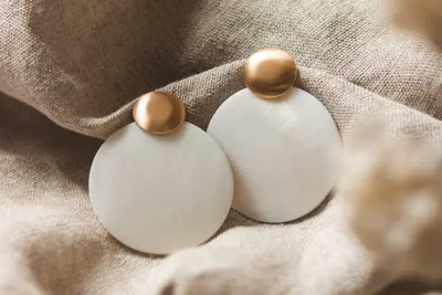 Two gold and white stud earrings.