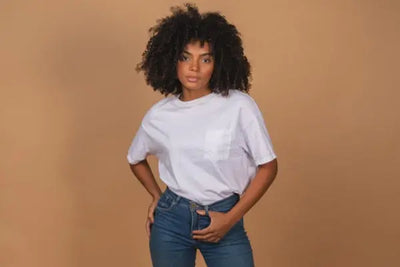 A woman standing with jeans and a white tee shirt that was made in America with organic cotton.