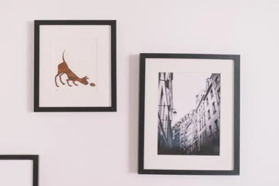 Two pieces of wall decor, one with an image of a city and the other with a print of a dog, were made in America and purchased on a marketplace. 