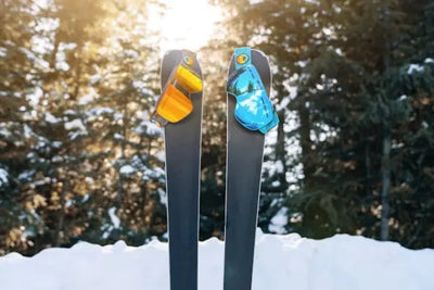 Two skis and snow masks in the snow.