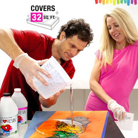 A man pours ArtResin 1 Gal (3.78 L) Epoxy Resin onto colorful art while a woman smiles and watches. Both wear gloves. Two ArtResin bottles on the table. Text above: Covers 32 sq. ft., UV protection, with a rainbow painting in the background.