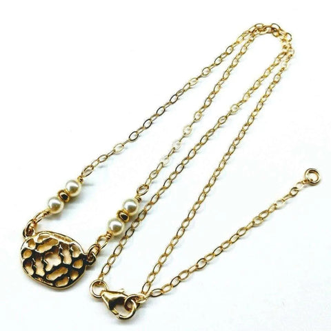 The As Seen on Molly Ringwald 14K Gold Filled Filigree Pearl Choker Necklace by Alexa Martha Designs features a textured oval pendant and small white pearls on one side, displayed against a white background.