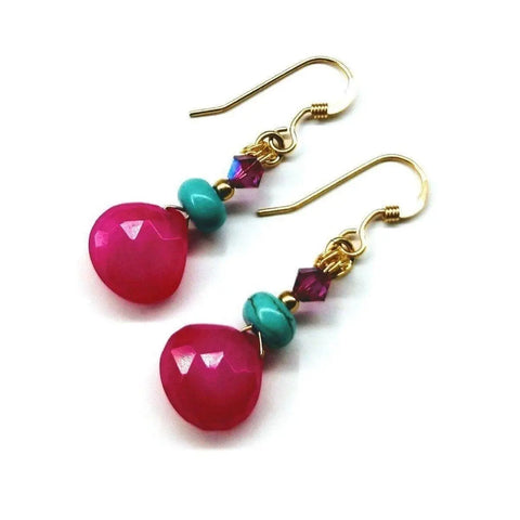 Alexa Martha Designs’ 14 KT Gold Filled Wire Wrapped Pink and Turquoise Drop Gemstone Earrings feature faceted hot pink chalcedony teardrops, turquoise beads, and small purple crystals for a vibrant look.