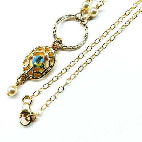 The 14K Gold-Filled Hammered Open Circle Filigree Necklace by Alexa Martha Designs features a blue-green gemstone pendant, textured ring, Swarovski crystal pearls, adjustable clasp, and delicate links. Handmade in Montana.