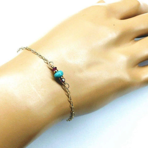 The 14K Gold Filled Pink and Turquoise Gemstone Dainty Bracelet by Alexa Martha Designs is displayed on a mannequin hand, highlighting its delicate handmade elegance with pink and turquoise beads.