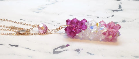 The Alexa Martha Designs 14K Rose Gold Fill Super Sparkly Mom Crystal Pillar Pendant Necklace showcases a clustered pendant with faceted purple, iridescent, and light pink beads on a white marbled surface.
