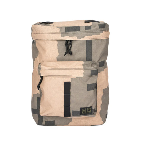 The MIS Backpack - T Pattern features a tan and green camo design, front zip pocket, black zipper pulls, internal laptop holder, and an “MIS” logo patch on the bottom right.