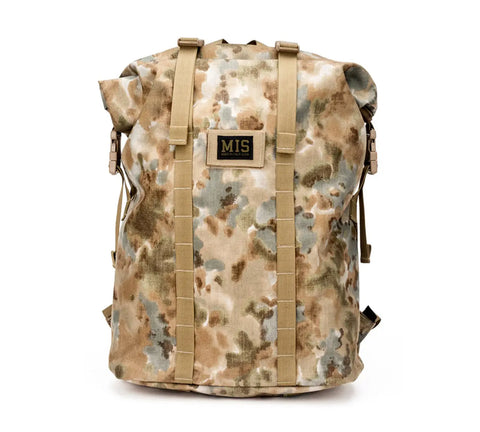 The MIS Roll Up Backpack - Covert Desert features a camouflage Cordura nylon body, tan straps, and a rectangular MIS patch on the front. This 30L laptop backpack is made in the USA and shown against a white background.