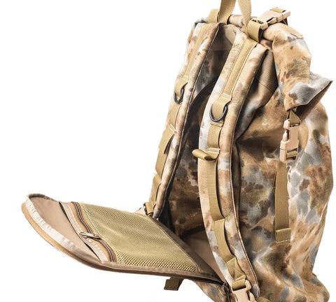 The MIS Roll Up Backpack - Covert Desert features a tan and green camo Cordura nylon build with its back panel and zippered mesh pocket open, showing padded shoulder straps, multiple straps, and buckles.