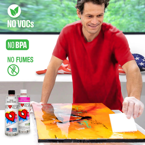 A man in a red shirt applies ArtResin 32 Oz Epoxy Resin Starter Pack to colorful art with a spatula. Bottles of resin sit in front, with text: NO VOCs, NO BPA, NO FUMES. An American flag is visible in the background.