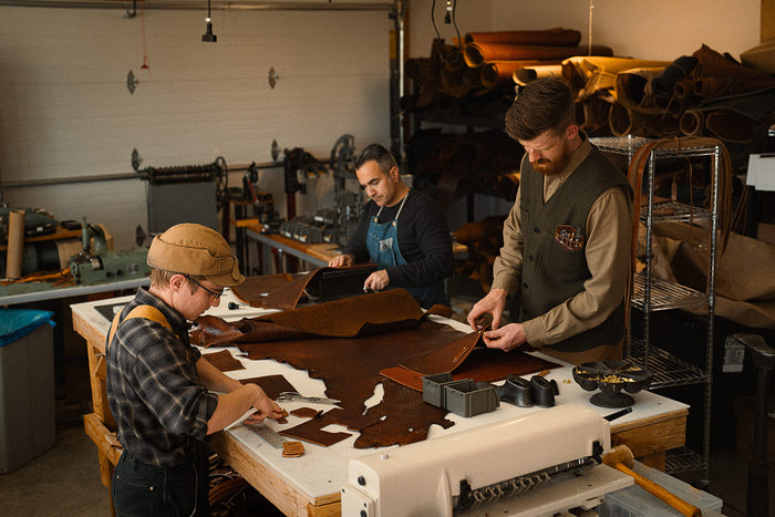 Three men working in a leather workshop.