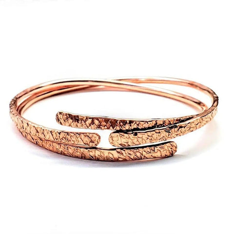The Adjustable Hammered Copper Overlap Bangle by Alexa Martha Designs features a textured design, adding a unique and elegant touch to any outfit for him or her.