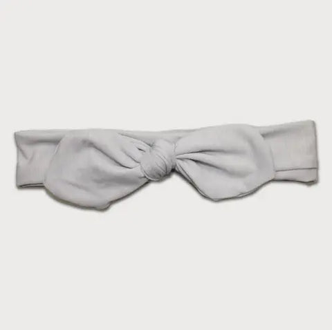 The Goodnighties Knotted Bow Headband is a handmade, light gray headband featuring a large center bow, displayed on a plain white background.