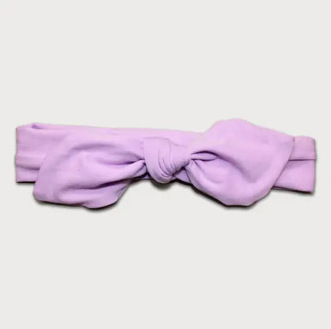 The Goodnighties Knotted Bow Headband features a light purple color with a simple center knot, shown against a plain white background.