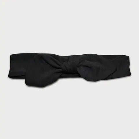 The Goodnighties Knotted Bow Headband in black, handmade in the USA, is displayed flat on a light gray background.