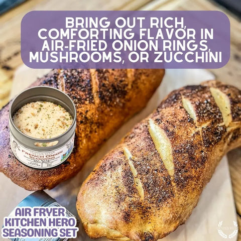 Two loaves of bread sit on a wooden board next to a tin of Gustus Vitae’s Air Fryer Gourmet Seasoning Set – Six Artisanal Spice Blends. Text suggests using these USA-made blends to season air-fried onion rings, mushrooms, or zucchini.
