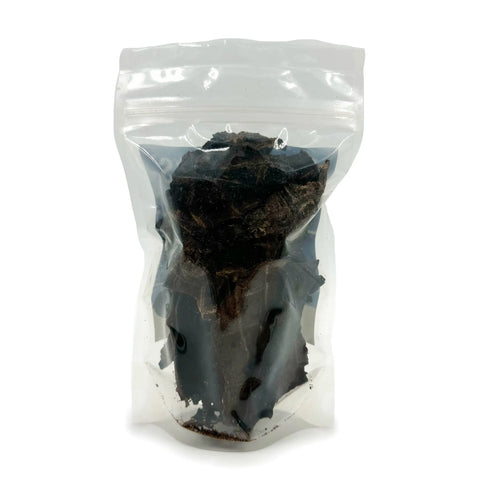 A clear resealable plastic bag of Brewscuits All Dried Up, filled with dark, dried plant material, is displayed against a white background.