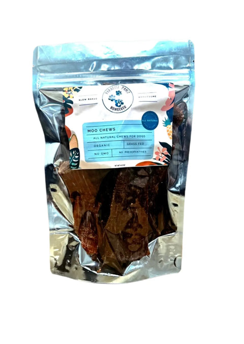 A clear resealable bag labeled Moo Chews by Dogtown Bakery contains brown, dried dog treats made from grass-fed beef. The label highlights all-natural, organic chews for dogs with no GMO and no preservatives for a nutritious treat.