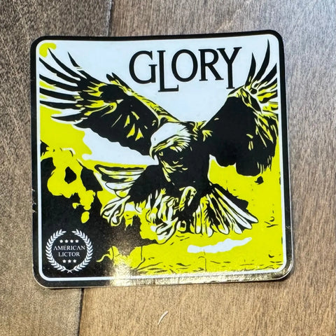 The Sticker: Bald Eagle - Glory by American Lictor features a bold black-and-yellow eagle in flight with “GLORY” above and an American Lictor emblem—ideal patriotic decor for proud enthusiasts.