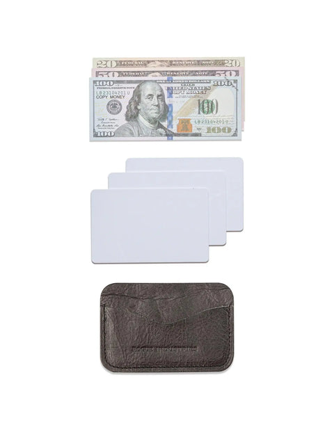 A stack of U.S. $100 bills, three blank white cards, and the Rogue Industries Bison Card Case are arranged vertically on a white background.