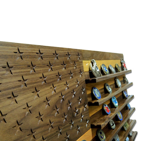 The Legacies of America Woodworking Companys American Flag Challenge Coin Display—crafted from walnut and cherry—features carved stars on the left and shelves for coins on the right, all set against a white background.