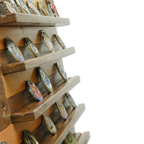 The American Flag With Firefighter Cross Challenge Coin Display by Legacies of America Woodworking Company features walnut and cherry wood, angled shelves for coins, and is shown side view with a white background on the right.