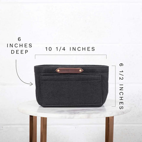A black rectangular Urban Southern Tote Insert, measuring 10 1/4 W x 6 1/2 H x 6 D, sits on a round marble table—lightweight and perfect for customizable organization inside your tote.