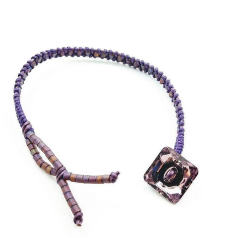 The Amethyst Braided Leather Swarovski Crystal Square Button Bracelet by Alexa Martha Designs is shown on a white background.